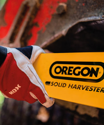Hand mit roten KOX-Arbeitshandschuhen hlt eine gelbe Harvester-Fhrungsschiene mit OREGON-Logo und der Aufschrift Solid Harvester.